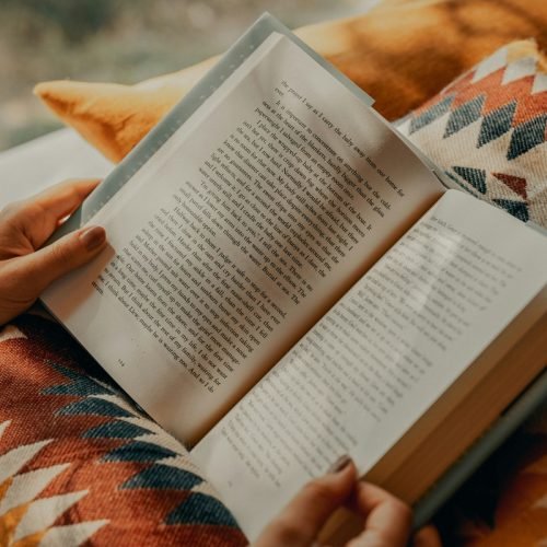 1 de 1 Imagem colorida de uma pessoa sentada no chão lendo um livro - Metrópoles - Foto: Clay B...